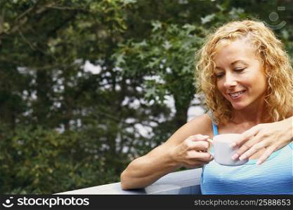 Close-up of a mature woman holding a cup of tea and smiling