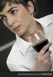 Close-up of a mature woman holding a glass of red wine