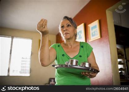 Close-up of a mature woman holding a tray and gesturing