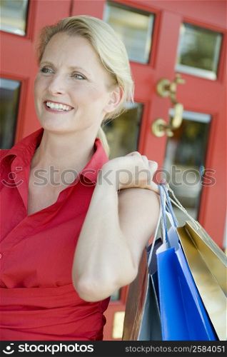 Close-up of a mature woman holding shopping bags and smiling
