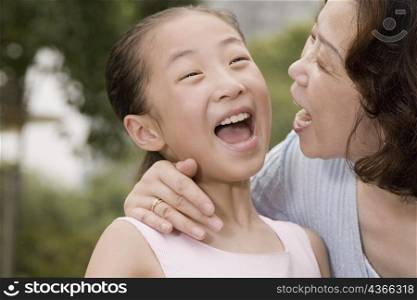 Close-up of a mature woman laughing with her granddaughter