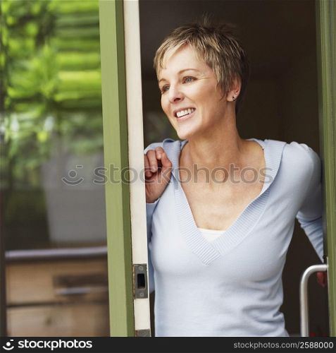 Close-up of a mature woman leaning against a door