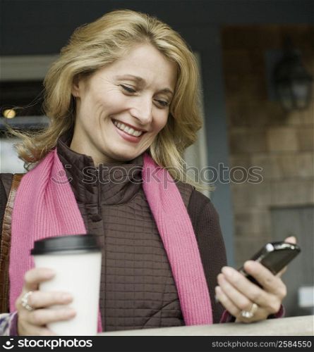 Close-up of a mature woman looking at a mobile phone and smiling