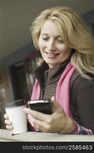 Close-up of a mature woman looking at a mobile phone and smiling