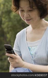 Close-up of a mature woman operating a mobile phone