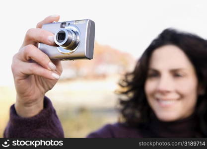 Close-up of a mature woman photographing with a digital camera