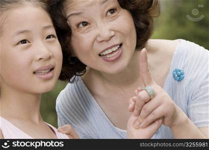 Close-up of a mature woman pointing with her granddaughter