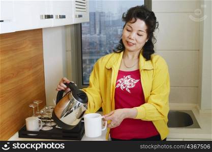 Close-up of a mature woman pouring coffee into a cup