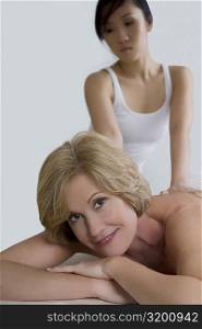 Close-up of a mature woman receiving a back massage from a massage therapist