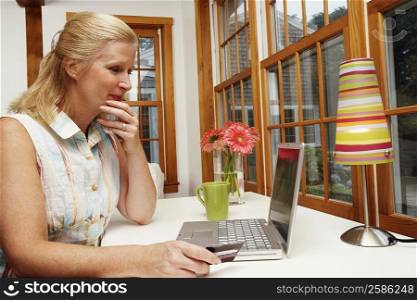 Close-up of a mature woman shopping online