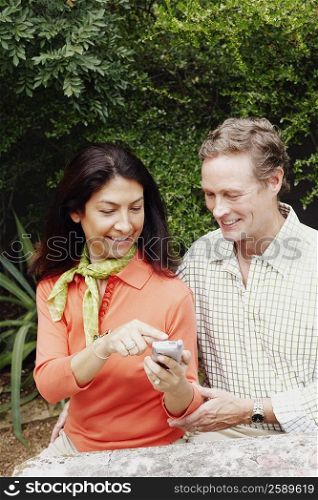 Close-up of a mature woman showing a mobile phone to a mature man