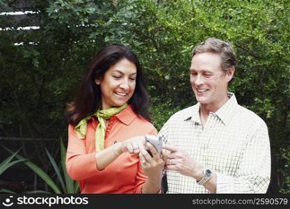 Close-up of a mature woman showing a mobile phone to a mature man