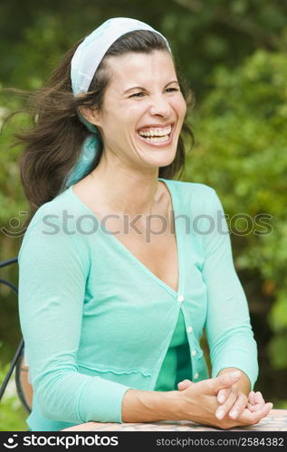 Close-up of a mature woman sitting at a table and laughing