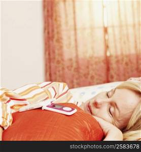 Close-up of a mature woman sleeping on the bed with a flip phone on the pillow