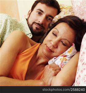 Close-up of a mature woman sleeping with a mature man lying behind her