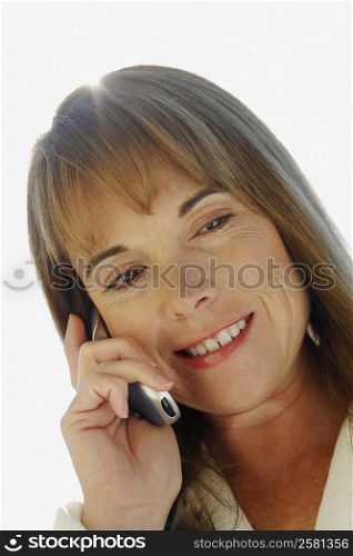 Close-up of a mature woman smiling and talking on a mobile phone