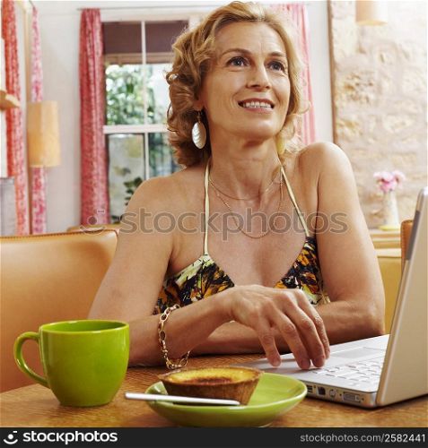 Close-up of a mature woman smiling in front of a laptop
