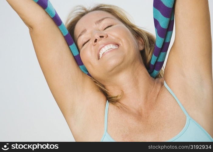 Close-up of a mature woman smiling with her arms raised