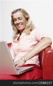 Close-up of a mature woman using a laptop and smiling