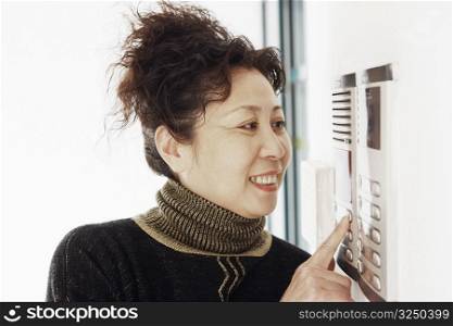 Close-up of a mature woman using an intercom