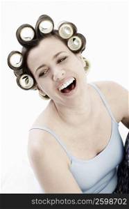 Close-up of a mature woman wearing hair curlers and laughing