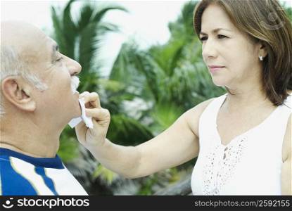 Close-up of a mature woman wiping a mature man&acute;s chin