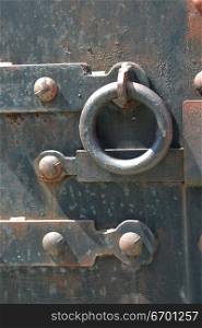 Close-up of a metal door with a round handle