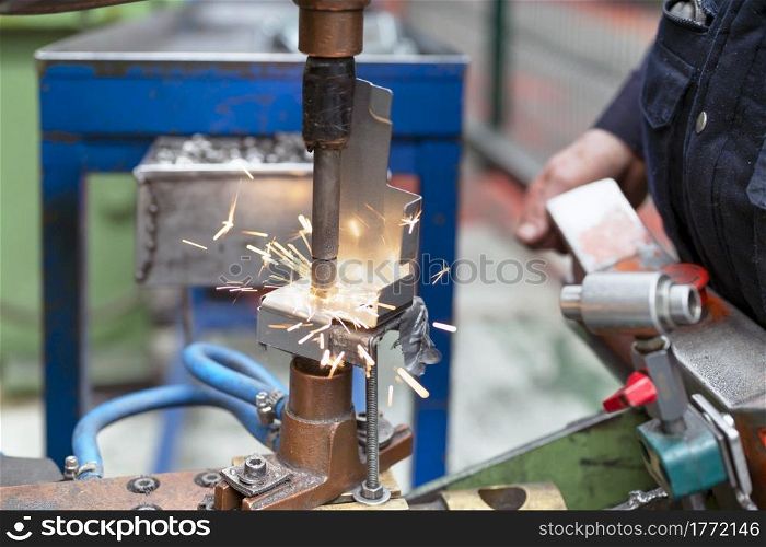 Close up of a metal element being spot-welded by a factory worker. Industry concept. High quality photo. Close up of a metal element being spot-welded by a factory worker. Industry concept.