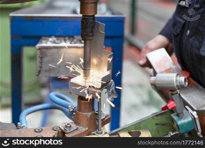 Close up of a metal element being spot-welded by a factory worker. Industry concept. High quality photo. Close up of a metal element being spot-welded by a factory worker. Industry concept.