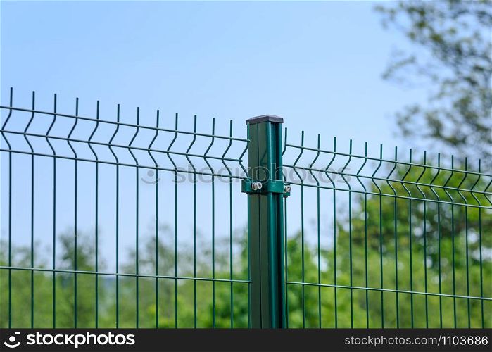 Close-up of a metal fence wire on blue sky background
