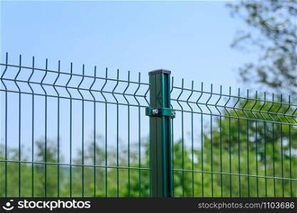 Close-up of a metal fence wire on blue sky background