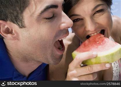 Close-up of a mid adult couple eating a slice of watermelon