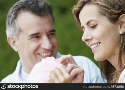 Close-up of a mid adult couple eating cotton candy