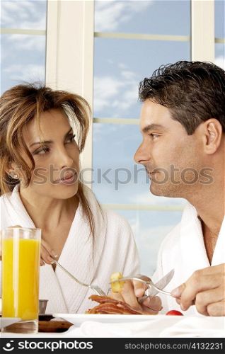 Close-up of a mid adult couple having breakfast and looking at each other