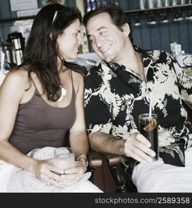 Close-up of a mid adult couple holding glasses of drink in a restaurant