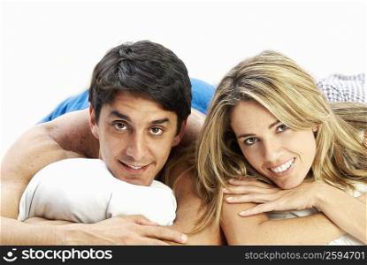 Close-up of a mid adult couple lying on the bed and smiling