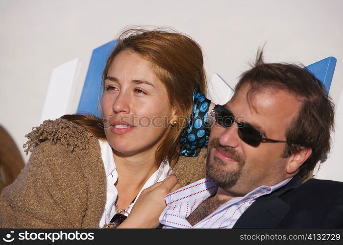 Close-up of a mid adult couple reclining on a lounge chair