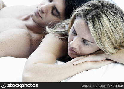 Close-up of a mid adult couple sleeping on the bed