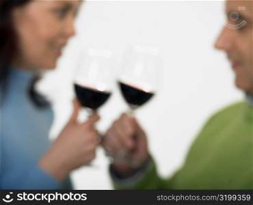 Close-up of a mid adult couple toasting glasses of wine