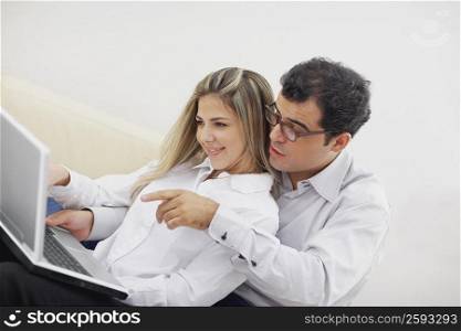 Close-up of a mid adult couple using a laptop
