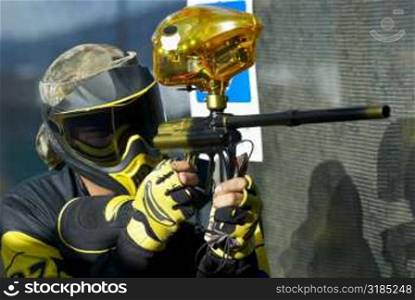 Close-up of a mid adult man aiming with a paintball gun