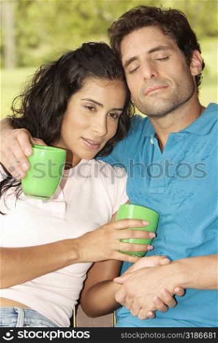 Close-up of a mid adult man and a young woman holding coffee cups