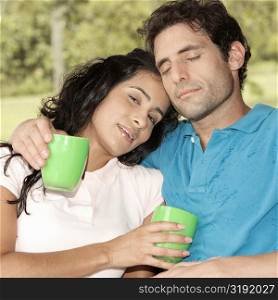 Close-up of a mid adult man and a young woman holding coffee cups