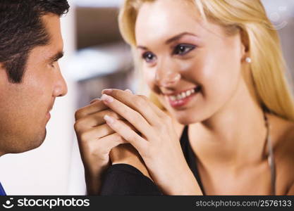 Close-up of a mid adult man and a young woman holding hands