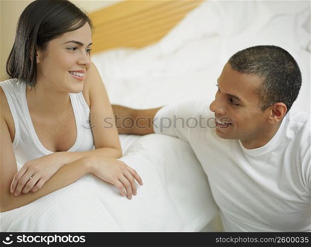 Close-up of a mid adult man and a young woman looking at each other and smiling