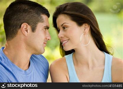 Close-up of a mid adult man and a young woman looking at each other