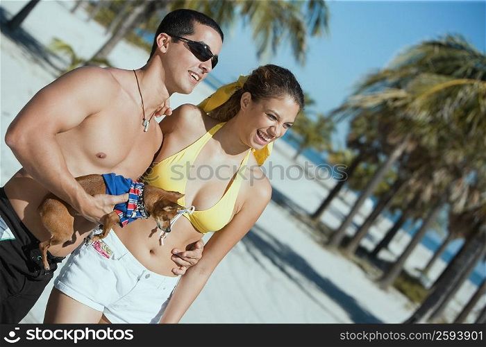 Close-up of a mid adult man and a young woman standing on the beach