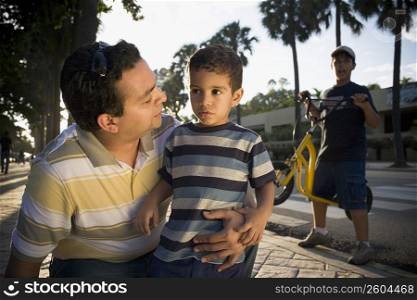 Close-up of a mid adult man and his son, Malecon, Santo Domingo, Dominican Republic