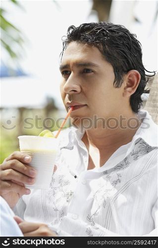 Close-up of a mid adult man drinking a glass of juice