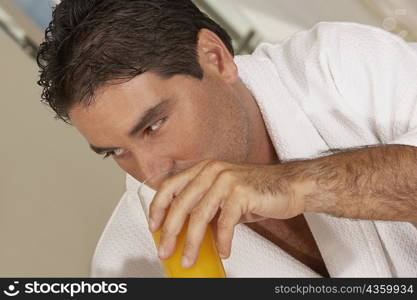 Close-up of a mid adult man drinking a glass of juice